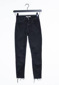 Svarta denim skinny jeans med medelhög midja, fem-ficksdesign och fransade fållar. Materialet är mjukt med en lätt stretch.