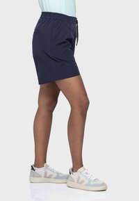 Marineblaue Shorts mit elastischem Bund, Kordelzug und Seitentaschen. Leichtes Material, lässiges Design, knielanger Schnitt.