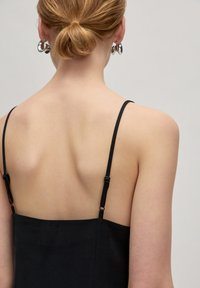 Schwarzes Spaghettiträgerkleid mit einem figurbetonten Rücken und geradem Ausschnitt, ausgestattet mit verstellbaren Trägern und einem strukturierten Stoff.