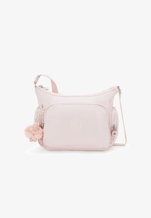 Světle růžová nylonová crossbody taška s kulatým tvarem, která má přední zipovou kapsu, embosované logo a chlupatý klíčový řetízek s opicí.