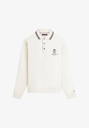 Polo de manga larga blanco con cuello de rayas negras, tres botones y logotipo de Tommy Hilfiger en el pecho y el puño de la manga.