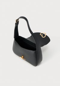 Μαύρη δερμάτινη τσάντα ώμου με χρυσή καρδιά στολίδι και μπροστινό κούμπωμα. Διαθέτει ομαλή υφή και στρογγυλεμένο σχήμα, ανοιχτό σχεδιασμό επάνω μέρος.