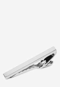 Silberner Krawattenclip mit einem schlanken rechteckigen Design, das eine polierte Metalloberfläche und einen strukturierten Griff darunter für einen sicheren Halt bietet.