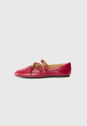 Ballerines en cuir rouge avec un bout pointu, deux brides avec des accessoires en métal doré, et une semelle noire à profil bas. Texture lisse.