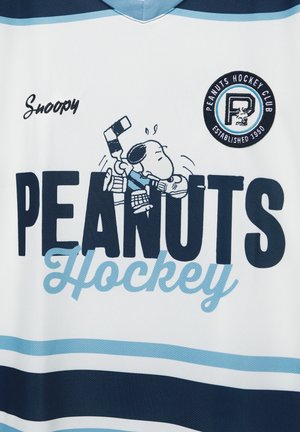 Bijeli hokejaški dres s natpisom "PEANUTS Hockey" velikim crnim slovima, plavim naglascima i slikom Snoopyja u hokejaškoj opremi. Okrugla značka na prsima.