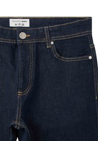 Granatowe dżinsy z żółtym przeszyciem, metalowym zapięciem na guzik oraz przednimi kieszeniami wzmacnianymi nitami. Metka wskazuje rozmiar 46 ITA, 31 USA, 42 EU.