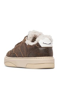 Sneaker in pelle marrone con una fodera bianca pelosa, punta rotonda e suola testurizzata. Presenta un accento bianco sul tallone con una grafica minimal.