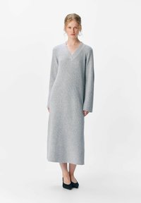 Abito lungo grigio a coste con scollatura a V e maniche lunghe, caratterizzato da una silhouette dritta e una trama sottile.