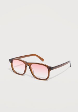 Montura cuadrada translúcida marrón para gafas con lentes de degradado rosa descansando sobre una superficie clara.