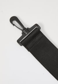 Curea din nailon negru cu un clips robust. Prezintă un material texturat și un cârlig din plastic pentru o atasare sigură. Design simplu cu accesorii funcționale.