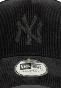 Fekete kord sapka kiemelt sötétszürke New York Yankees logóval. Egy kerek New Era címke található rajta, az alján az "Állítható" felirattal.