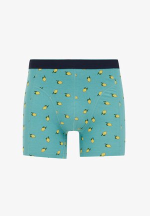 Herrarnas boxertrosor i turkost bomull med ett mönster av små gula citroner med gröna blad, kantade av en mörk marinblå midjeband.