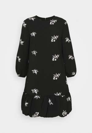 Robe noire à manches longues avec broderie florale blanche, encolure ronde, manches bouffantes et ourlet à volants froncés.