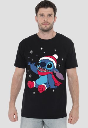 Schwarzes T-Shirt mit einem Cartoon-Charakter mit blauer Haut, der einen rot-weißen Weihnachtsmannhut und -schal trägt, umrandet von weißen Schneeflocken.