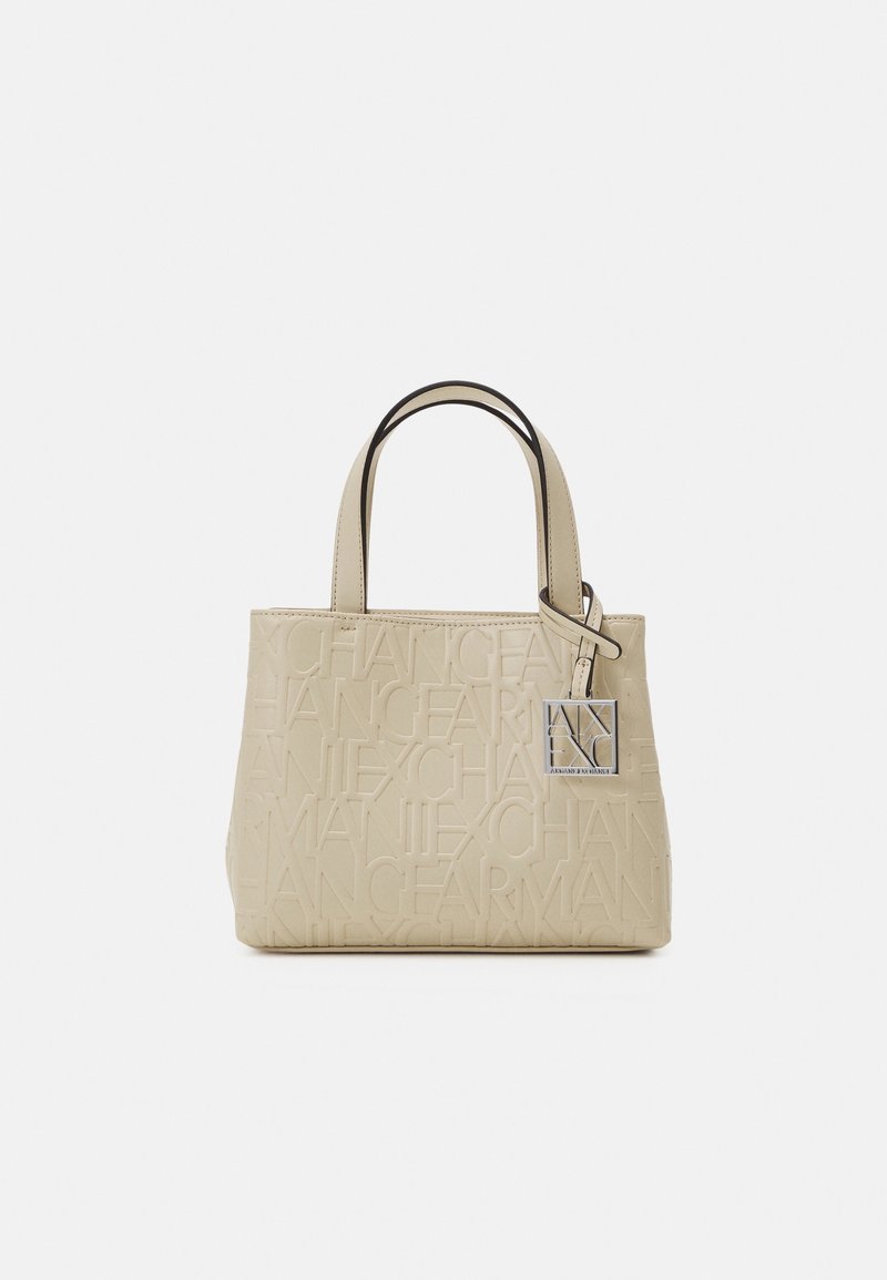 Sac à main rectangulaire beige avec texte en relief répété, deux poignées et une étiquette logo carrée en argent suspendue à une des poignées.