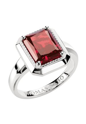 Silberner Ring mit einem großen rechteckigen roten Edelstein in einer vierstrebigen Fassung, mit "THOMAS SABO" auf dem Ringband graviert.