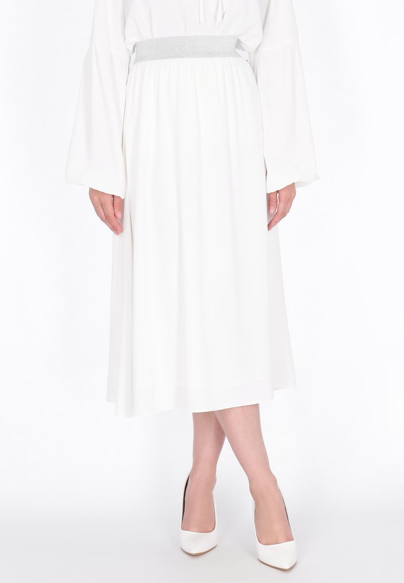 Witte midi-rok met een grijze elastische tailleband, gecombineerd met witte hoge hakken. De stof is soepel en vloeiend, met een lichte textuur.