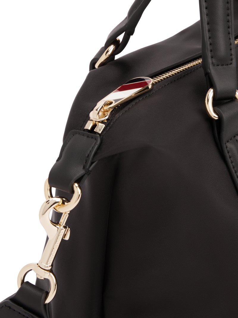 Sac à main en nylon noir doté d'une fermeture éclair dorée, d'une surface texturée et d'un accent matériel décoratif avec des détails rouges, blancs et bleus.