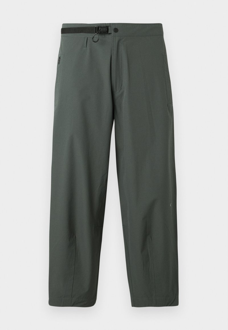 Pantalons légers de couleur vert foncé en tissu synthétique. Présentent une taille ajustable, des poches latérales et une coupe droite.