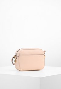 Obdélníková kabelka přes rameno z měkké růžové texturované kůže. Má zipové zapínání, malý zámek jako ozdobu a nastavitelný popruh.