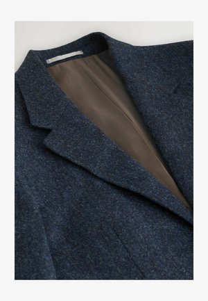 Marineblaues Wollblazer mit Reverskragen, strukturierter Außenseite und glattem braunem Innenfutter mit Fischgrätmuster.