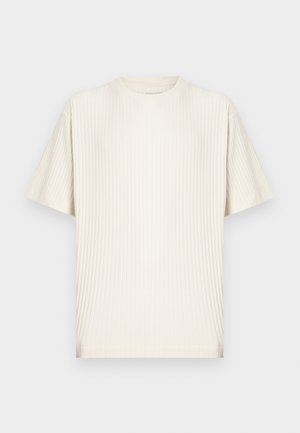 Krém színű, bordázott, rövid ujjú, kerek nyakú póló laza szabással, egyszínű világos háttéren bemutatva.