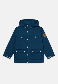 Navy blue hooded jacket made of durable fabric, featuring silver snap buttons, four front pockets, and a brown logo patch on the sleeve.