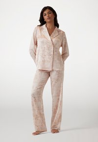 Hellrosa Satin-Schlafanzugset mit einer doppelbrüstigen Bluse im floralen Muster und weitem Hosenbein, weicher Textur und lässiger Passform.