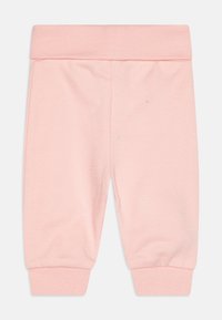 Svijetlo roza pamučne trenerke s rebrastim pojasom i manžetnama, glatke teksture, bez vidljivih uzoraka ili ukrasa.