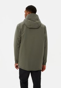 Giacca impermeabile verde oliva con cappuccio, polsini elasticizzati e design dritto. Texture liscia e dettagli minimal.