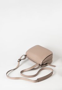 Hellbeige Leder-Umhängetasche mit rechteckiger Form, Reißverschlussverschluss, verstellbarem Tragegurt und dezentem Branding an der Seite.