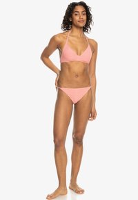 Rosa texturerad bikini med triangel-topp och låga trosor. Tyget har ett subtilt mönster och är utformat för en säker passform.