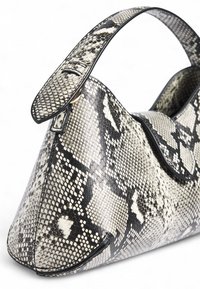 Gyvatės rašto krepšys, pagamintas iš tekstūruotos odos; turi lenktą formą, lygias detales ir trumpą diržą, skirtą nešimui rankoje. Juodos ir baltos spalvos derinys.