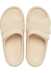 Beige rubberen sandalen met een gestructureerde voetbed, verstelbare stoffen band en een ronde vorm. Lichtgewicht ontwerp, geschikt voor casual gebruik.