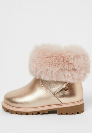 Botte enfant métallique rose avec une large bordure en fausse fourrure rose et une semelle brune robuste, logo sur le côté, conçue pour temps froid.