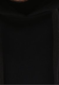 Sudadera negra con capucha de tela texturizada, con una gran capucha y un bolsillo delantero. El diseño es sencillo, sin logotipos ni patrones visibles.