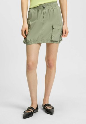 Szorty z elastycznym pasem w jasnym oliwkowym kolorze, z bocznymi kieszeniami cargo i marszczeniami na dole nogawek. Zaprojektowane dla wygody.