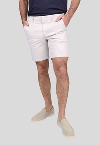 Shorts en coton gris clair avec une coupe décontractée, dotés de poches latérales et d'un devant plat. Accompagnés de chaussures à enfiler beiges.