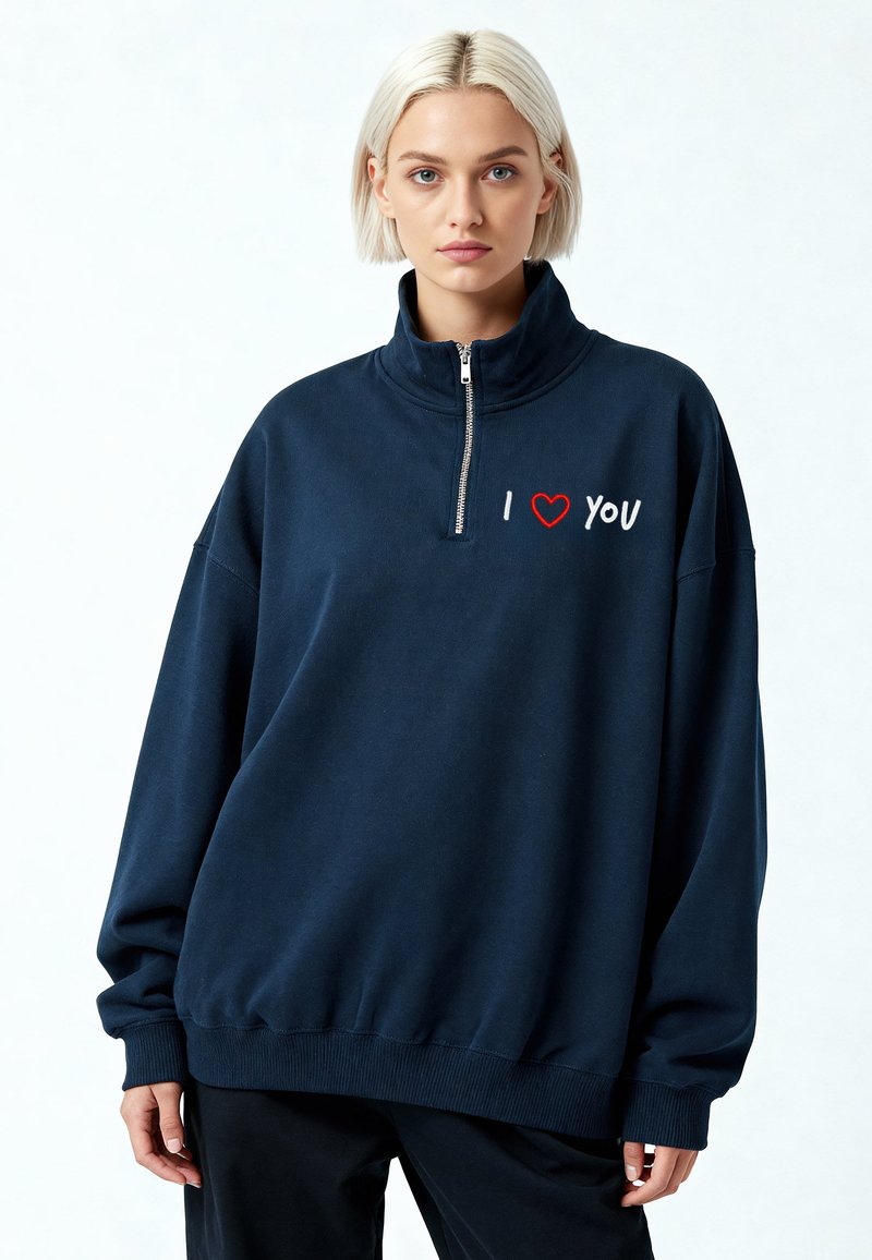 Sweat-shirt bleu marine avec col à demi-fermeture éclair, broderie rouge et blanche "I ❤️ YOU" sur la poitrine, poignets et ourlet côtelés.