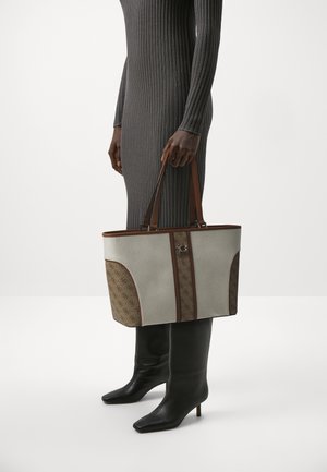 Borsa a tracolla in tessuto grigio con un pannello marrone a motivo, dotata di due manici marroni e un accento con logo. Texture liscia con forma strutturata.