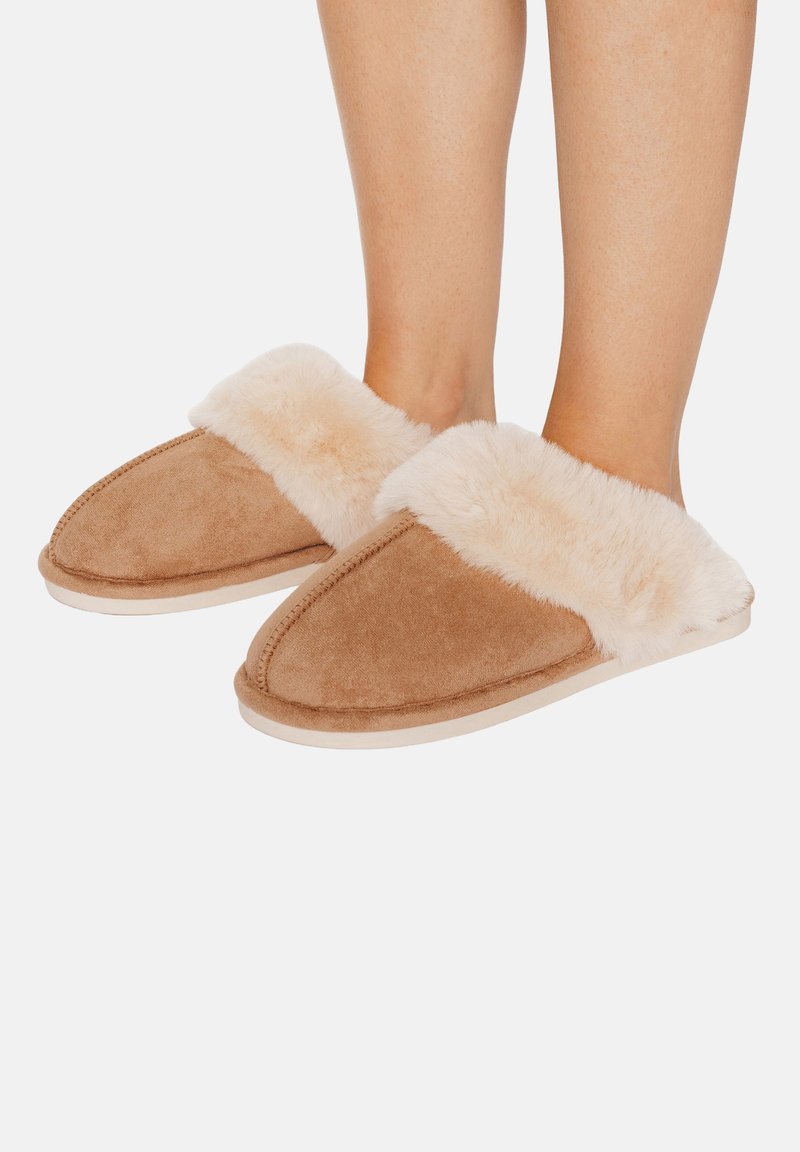 Chaussons couleur fauve avec un bord en fausse fourrure douce, dessus en daim, bout arrondi et semelle beige. Conçus pour le confort et la chaleur en intérieur.
