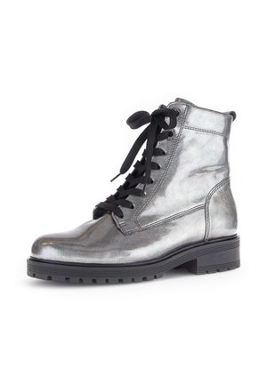 Zilveren metallic enkelboot met zwarte veters, ronde neus en textuurafwerking. Heeft een chunky zwarte zool en zijstiksels.
