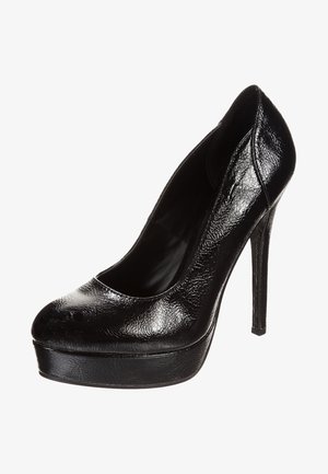 Escarpin à talon haut noir brillant pour femmes avec semelle compensée, bout rond et texture lisse sur fond blanc.