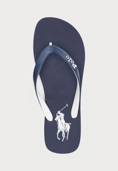 Navy blue flip-flop with white strap and embossed polo player graphic. Textured footbed adds grip and comfort. Lightweight design.