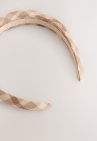 Beige ja ruskea ruudullinen kangaspanta, jossa on sileä pinta ja joustava sisävuori mukavuutta varten.