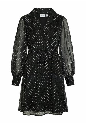 Czarna sukienka w białe grochy, z kołnierzem, długimi przezroczystymi bufkami na rękawach, paskiem wiązanym w talii oraz falującym dołem.