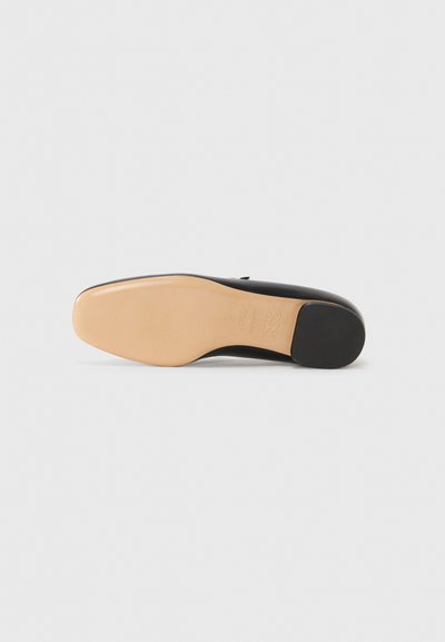 Sort skosål med en glat, lysebrun finish, der har en afrundet form og en let hæl. Holdbart materiale med minimal tekstur.