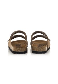 Sandali in suede marrone con retro aperto, multiple cinghie elastiche, suola in sughero e plantare testurizzato con logo del marchio.