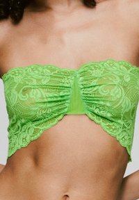 Groene kanten bandeau top met bloemmotief, geplooid middenstuk en gegolfde randen. Lichtgewicht en semi-doorzichtig materiaal.