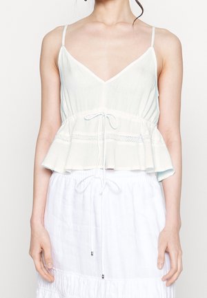 Top peplum azzurro chiaro con spalline sottili, scollatura a V, vita arricciata e dettagli in pizzo. Realizzato in un tessuto leggero e testurizzato.